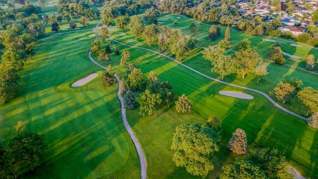 Aerial view of 2 fairways at sunrise.